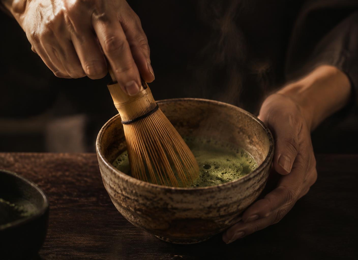 Hands whisking matcha